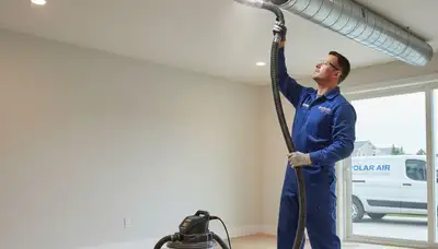 Technician performing air duct cleaning service in Kansas City, MO for improved HVAC efficiency
